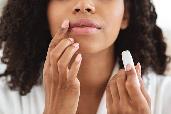 Woman applying moisturising chapstick on lips