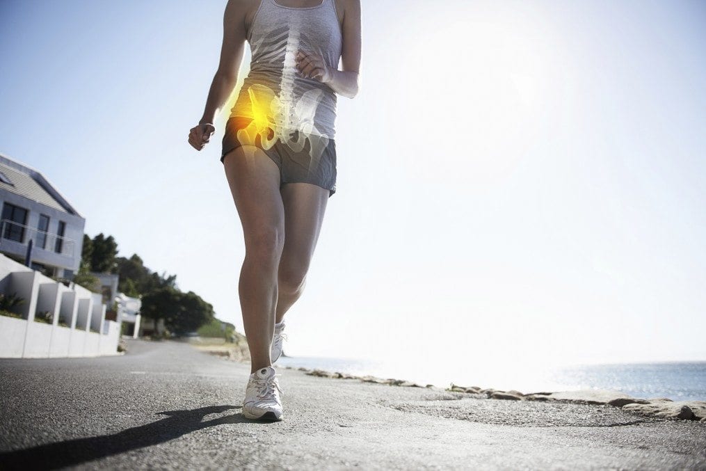 A cropped view of a female jogger on the road experiencing joint inflammation