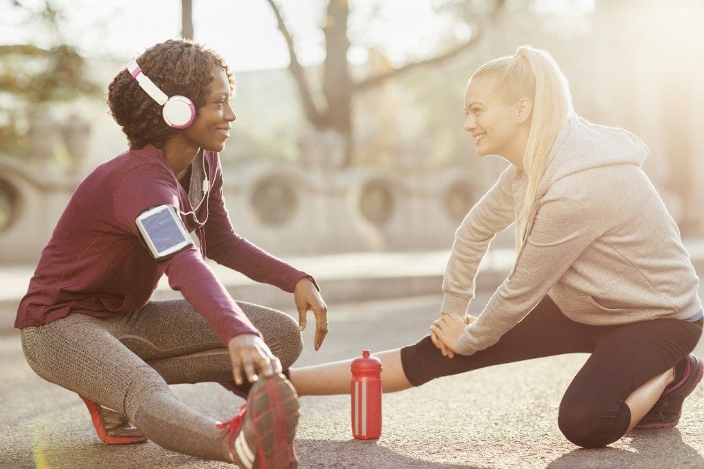 two women stretching before exercise