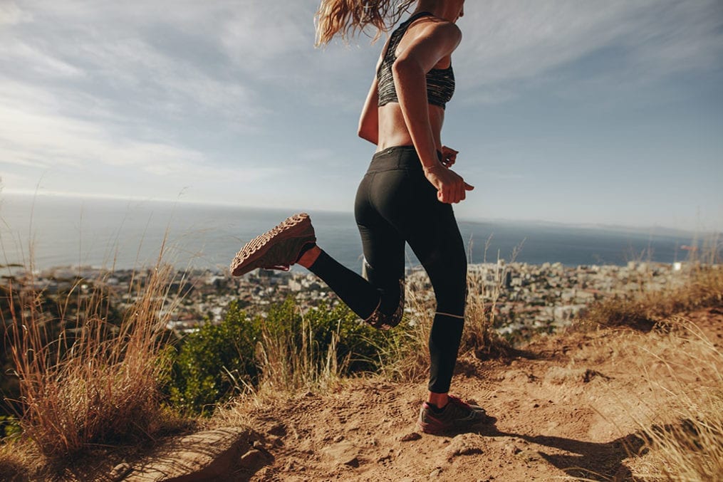 Young woman jogging on rocky path