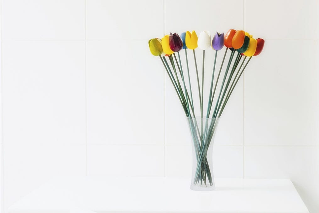 Tulips in a glass vase in a white room.